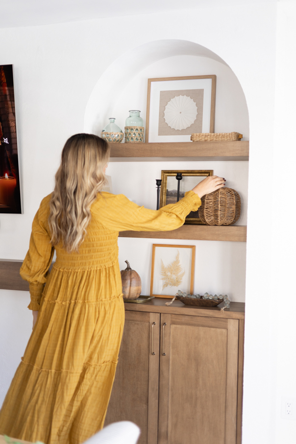 andi placed a pumpkin on her living room shelf