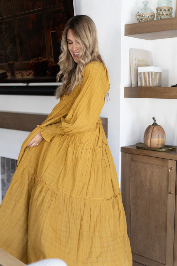 Andi smiling with her maxi dress find for Fall in her living room